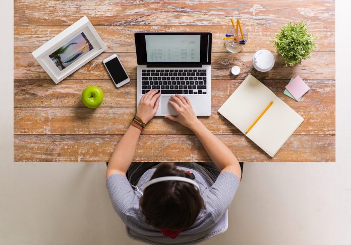 woman with receipt on laptop screen at office