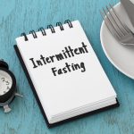 Intermittent fasting concept on blue table